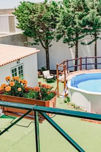 a patio with a pool and a planter with flowers at In My House Baleal in Baleal