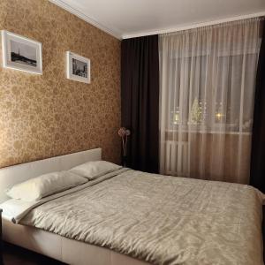 um quarto com uma cama grande e uma janela em Charme apartment em Jelgava