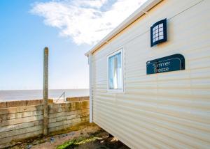 a building with a sign that reads summer lease next to the beach at Eastern Beach Caravan Park in Caister-on-Sea