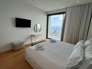 a bedroom with a large bed and a large window at Del Mar Beachfront Boutique Residence in Limassol +37 photos