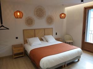 ein Schlafzimmer mit einem großen Bett und einigen Lichtern an der Wand in der Unterkunft Intense Boutik-Hôtel in Port-Vendres