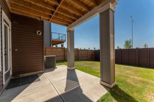 eine überdachte Terrasse mit einem Holzdach und einem Hof in der Unterkunft You will love this 2BR Guest Suite in SE Calgary in Calgary