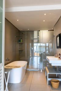a bathroom with a bath tub and a sink at 406 Les Mouettes in Ballito