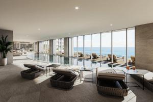 uma sala de estar com piscina e vista para o mar em Del Mar Beachfront Boutique Residence em Limassol