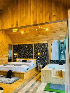 Jibhi的住宿－LITTLE WOOD TREEHOUSE，木制客房内的一间卧室,配有一张床