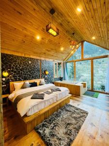 ein Schlafzimmer mit einem großen Bett in einem Holzzimmer in der Unterkunft LITTLE WOOD TREEHOUSE in Jibhi