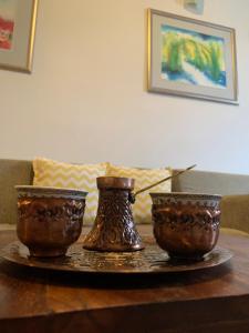deux vases assis au-dessus d'une table en bois dans l'établissement City moments Sarajevo, à Sarajevo