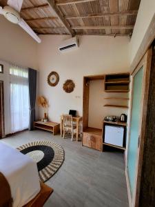 1 dormitorio con cama, escritorio y mesa en Drift Hideaway en Kuta Lombok