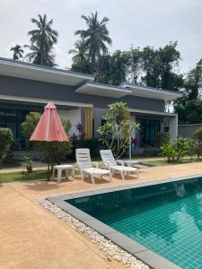 a villa with a swimming pool and a house at Oneandaman Resort in Khao Lak