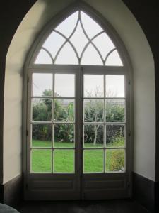 an arched window with a view of a garden at Azores Youth Hostels - Sao Miguel in Ponta Delgada