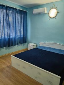 a bedroom with a bed and a blue wall at Хотел Тримата мускетари in Varna City