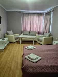 a living room with a bed and two couches at Хотел Тримата мускетари in Varna City
