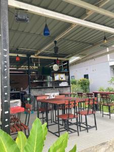 Oneandaman Resort في خاو لاك: مجموعة طاولات وكراسي تحت سقف