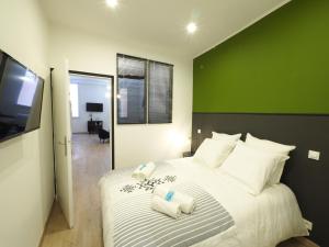 a bedroom with a large bed with a green wall at 06R - Beau T2 moderne - Vieux Nice in Nice