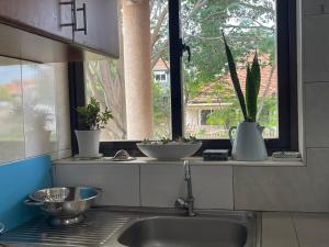 a kitchen counter with a sink and a window at Kim luxury apartment in Kampala +25 photos