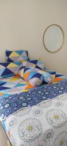a bed with colorful pillows on top of it at Villa Kayana EE6 - 3 Bedrooms in Batu