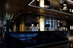 two people sitting at a desk in an office at Grand Plaza Hotel & Congress Center in Ljubljana