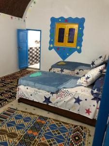Schlafzimmer mit einem Bett und einem Spiegel an der Wand in der Unterkunft Wesy Ka Guest House in Shellal