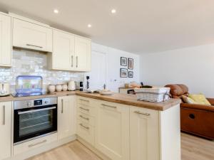 a kitchen with white cabinets and a counter top at Pier Lookout in Eastbourne