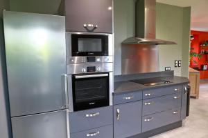 een keuken met roestvrijstalen apparatuur in een keuken bij Gîte des Zèbres Aventuriers... in L'Etang-Bertrand