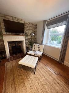 a living room with a couch and a fireplace at Rush Hill Cottage - with parking for 2 cars in Bath