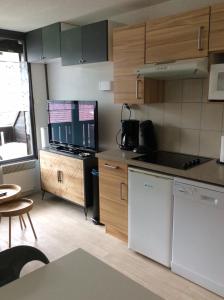 uma cozinha com armários de madeira e uma bancada em Grand Morillon - 104 - Montagne Belle Vue Studio 4 em Morillon