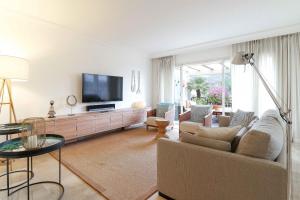 een woonkamer met een bank en een flatscreen-tv bij Duplex Penthouse in Rio Real Golf, Marbella in Marbella