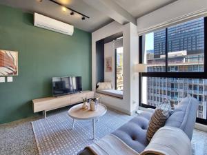 a living room with a blue couch and a tv at 9th floor views, couples dream- wifi-pool in Cape Town