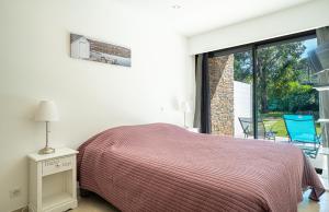 a bedroom with a bed and a large window at La villa Roméo, piscine et spa in Sainte-Maxime +42 photos