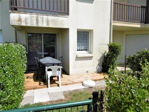 a wooden deck with a table and chairs on a house at Appartment Erwan in Arzon