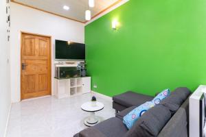 a living room with a couch and a green wall at Maafolhey Han'dhaan - Ukulhas in Ukulhas