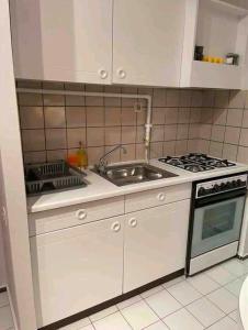 a white kitchen with a sink and a stove at Bakirkoy merkez in Istanbul