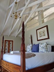 1 dormitorio con 1 cama grande y lámpara de araña en Churchill House, en Hillcrest