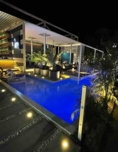 una piscina de agua azul por la noche en Beautiful house in Sabana Basora Aruba! en Savaneta