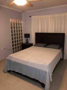 a bedroom with a large bed and a window at Beautiful house in Sabana Basora Aruba! in Savaneta