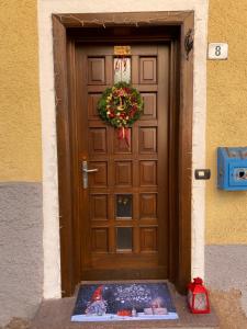 Una porta marrone con una corona di fiori di Casa Mia Fiemme a Carano
