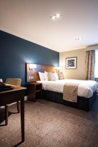 a hotel room with a large bed and a desk at Toby Carvery Strathclyde, M74 J6 by Innkeeper's Collection in Motherwell