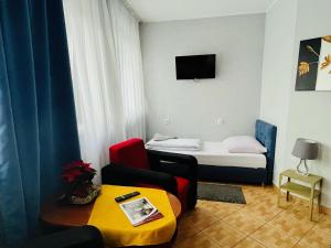 a small room with a bed and a couch and a table at Hotel Elda in Bydgoszcz
