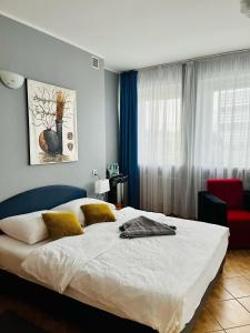 a bedroom with a large bed and a red chair at Hotel Elda in Bydgoszcz