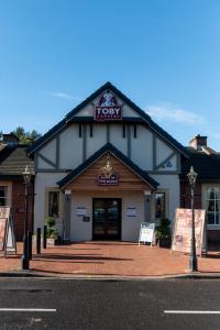 un bâtiment avec un panneau à l'avant dans l'établissement Toby Carvery Strathclyde, M74 J6 by Innkeeper's Collection, à Motherwell