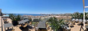 a patio with chairs and tables and a view of the ocean at Hotel Primavera Park in Benidorm