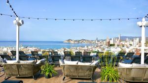 a patio with chairs and a view of the city at Hotel Primavera Park in Benidorm