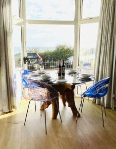einen Tisch mit 2 Stühlen und einen Tisch mit Weinflaschen darauf in der Unterkunft Palmerston House with Sea and Downs Views in Ventnor
