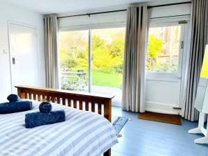 1 Schlafzimmer mit 2 Betten und einem großen Fenster in der Unterkunft Palmerston House with Sea and Downs Views in Ventnor