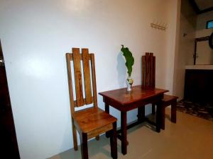 a table and a chair with a vase on it at LADY GHAGHA ROOM RENTALs in San Vicente