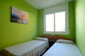 Duas camas num quarto verde com uma janela em BONAMAR Bxs 3 em L'Estartit
