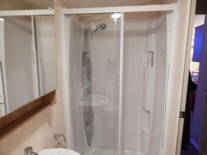 a shower with a glass door in a bathroom at Presthaven Sands Holiday Park 3 and 2 Bed Caravans in Prestatyn +27 photos