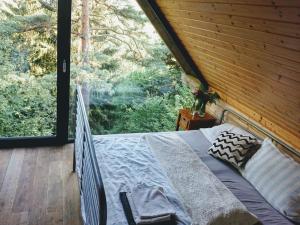 uma cama num quarto com uma grande janela em Mountain Lodge Azzy, surrounded by Ultimate Peace! em Valašské Klobouky
