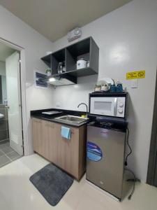 a small kitchen with a microwave and a refrigerator at CONDO unit in Puerto Princesa Palawan in Puerto Princesa City