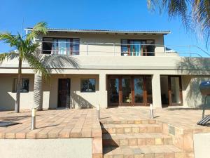 una casa con una palmera delante de ella en Beynespoort Farm, en Cullinan